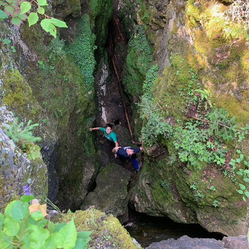 two boys looking up from within one of the deep crevices.