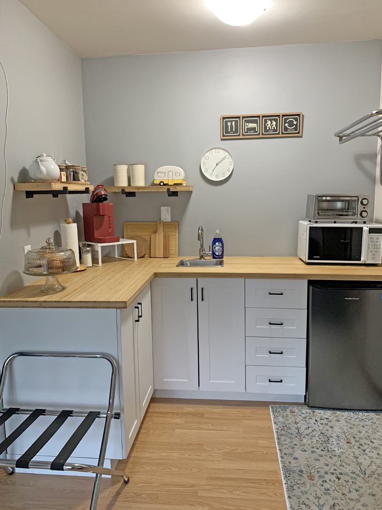 kitchen space with small sink, fridge, microwave and toaster oven